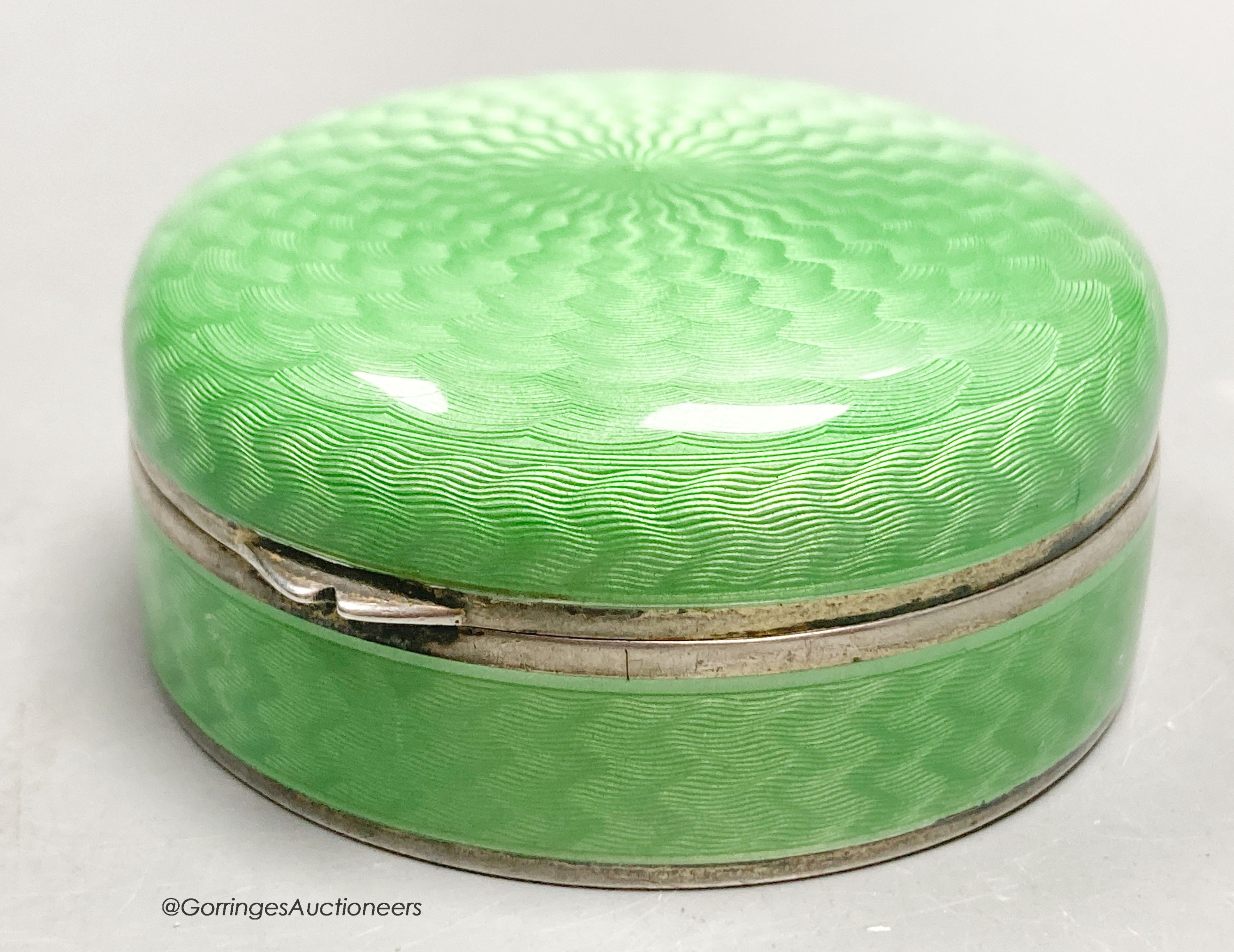 A 1920's continental silver and green guilloche enamel circular box and cover, with mirrored interior, import marks for P.H. Vogel, London, 1924, 55mm diameter by 24mm.